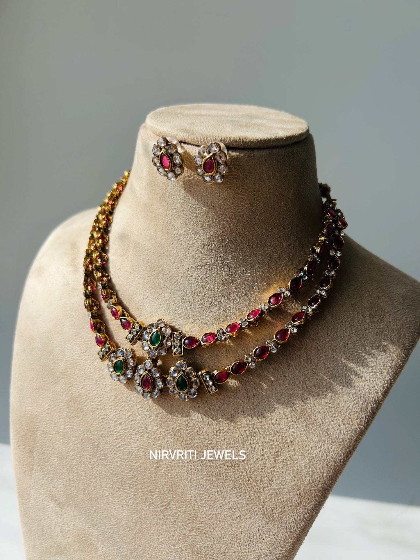 A dual-layered kundan necklace adorned with ruby and emerald