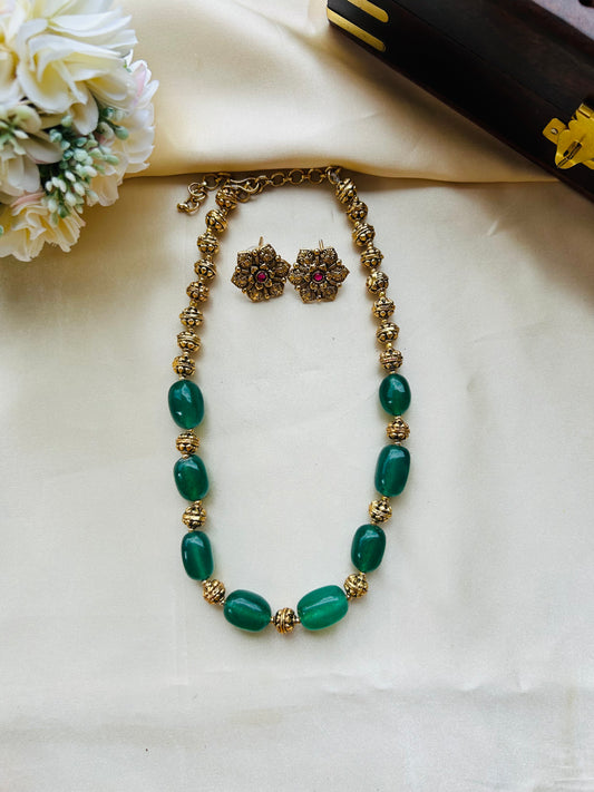 A timeless green gems and antique gold necklace set crafted to add effortless elegance