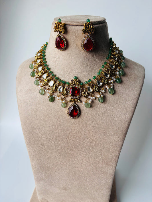 A stunning regal choker set adorned with ruby red stones, pearls, and emerald accents.