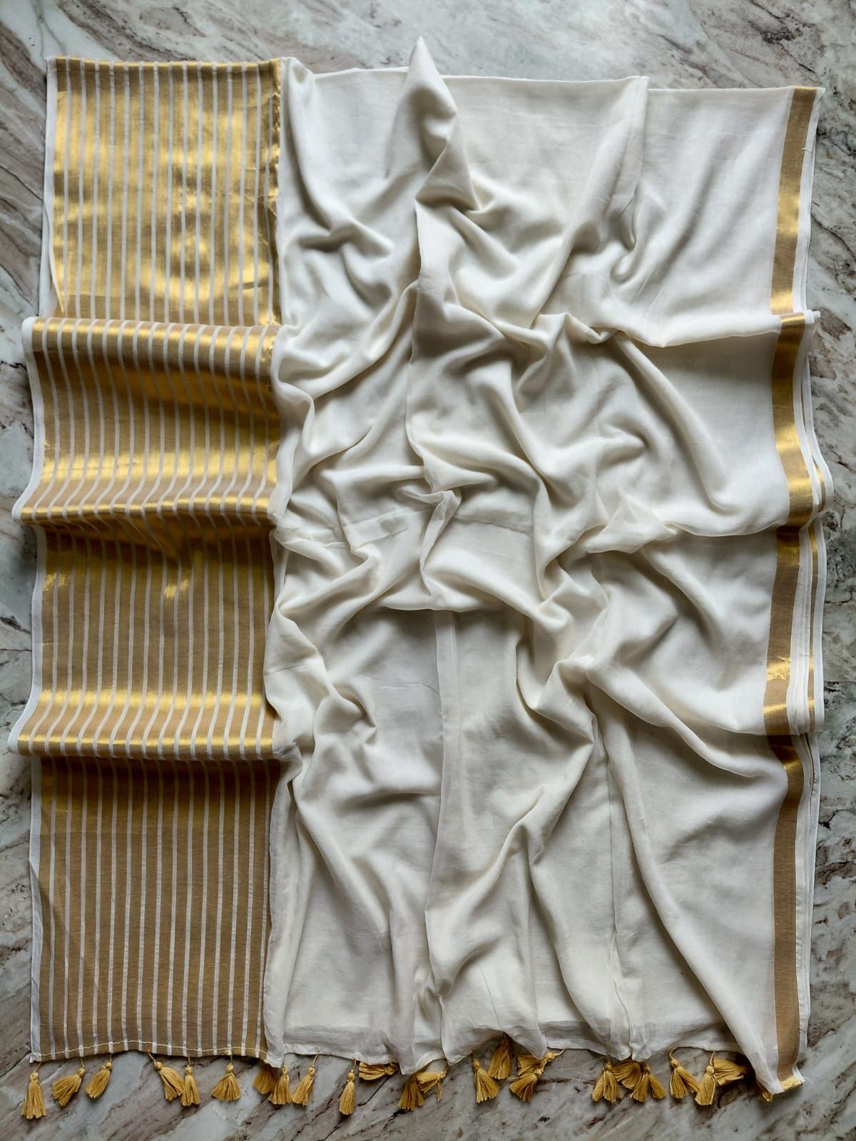 Pure and authentic mul cotton saree with broad gold zari line border on one side and small border on other side