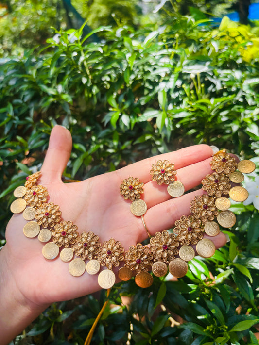 Traditional floral coin necklace set featuring vibrant red stones and an antique gold finish.