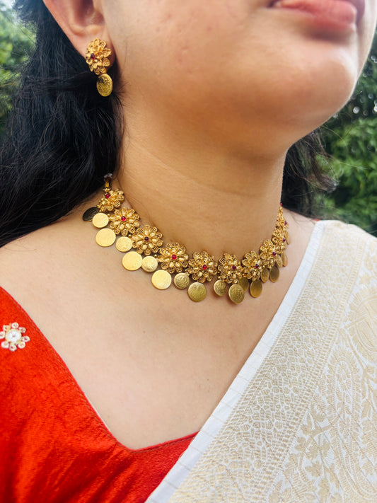 Traditional floral coin necklace set featuring vibrant red stones and an antique gold finish.